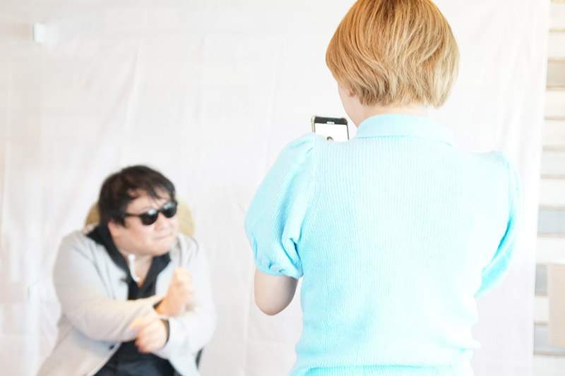 （ニシダさんをスマホで撮影するサーヤさん）