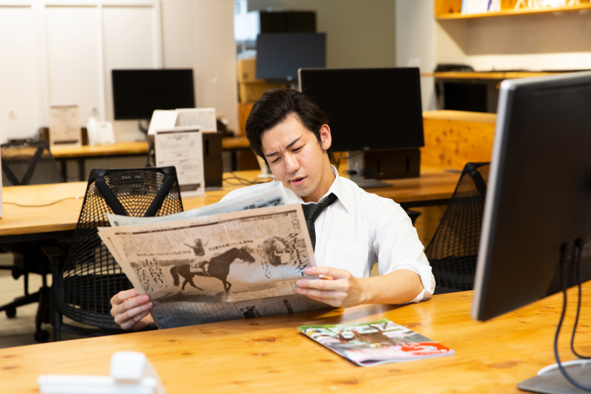 画像岡が競馬新聞を読んでいる画像